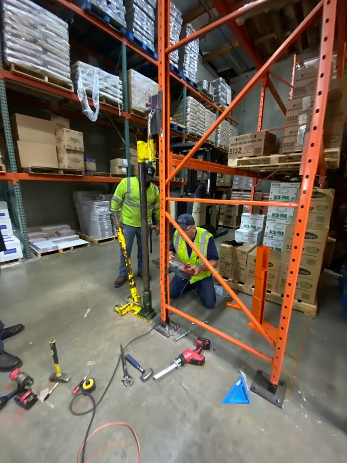 two people repairing pallet rack in a warehouse in Orange County